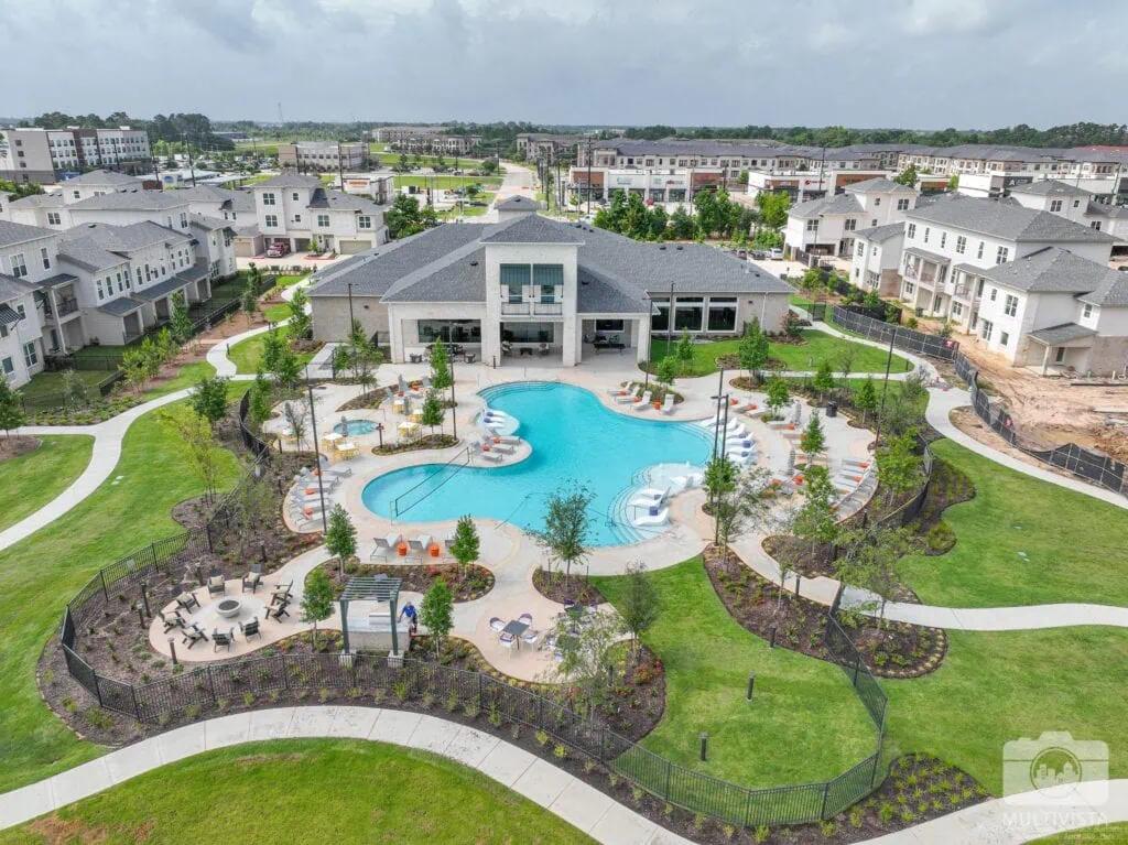 Aerial view of a community pool with surrounding lounge chairs and landscaping.