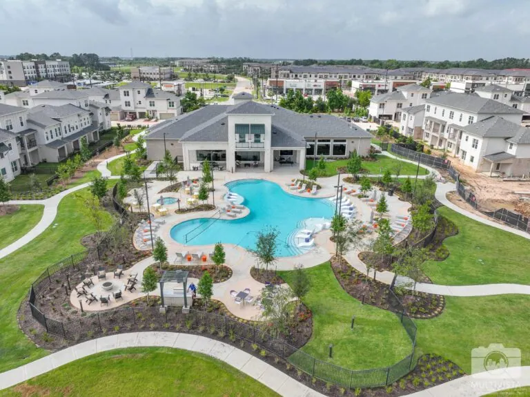 Aerial view of a community pool with surrounding lounge chairs and landscaping.
